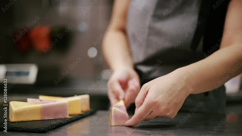 Confectioner puts cheesecake on a plate Confectioner puts cheesecake on a plate