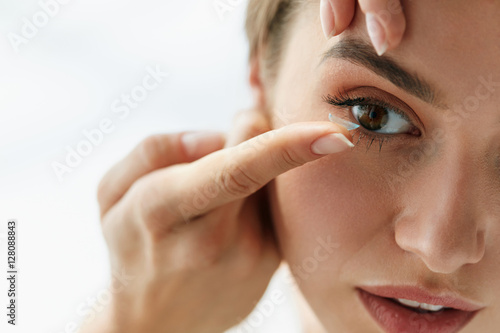 Vision Contact Lenses. Closeup With Beautiful Woman Face photo