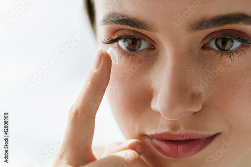 Fototapeta Naklejka Na Ścianę i Meble -  Closeup Of Beautiful Woman Applying Eye Lens In Eye