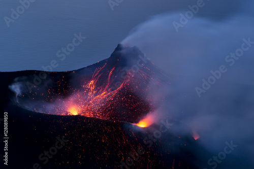 Lava and lapilli erupting from volcano at night, Lipari islands, Italy