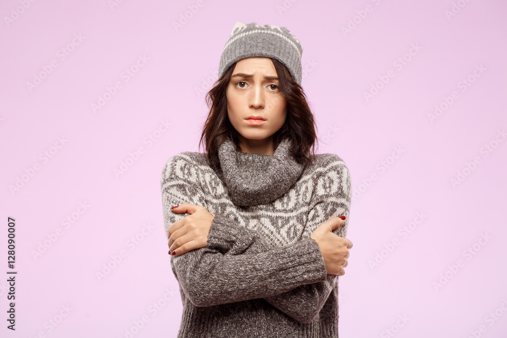 Sad young beautiful girl feeling cold over light background. Sad young beautiful girl feeling cold over light background.