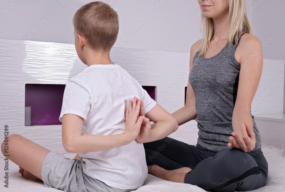 Mother and son doing yoga exercise at home. Sport, happy family concept Mother and son doing yoga exercise at home. Sport, happy family concept