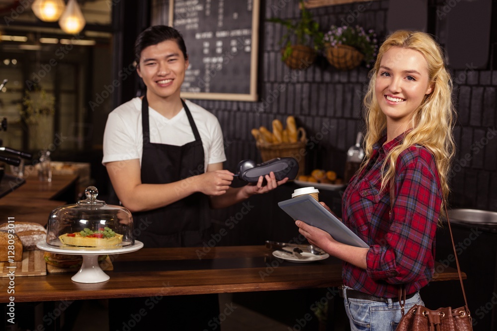 Smiling barista taking credit card from customer Smiling barista taking credit card from customer