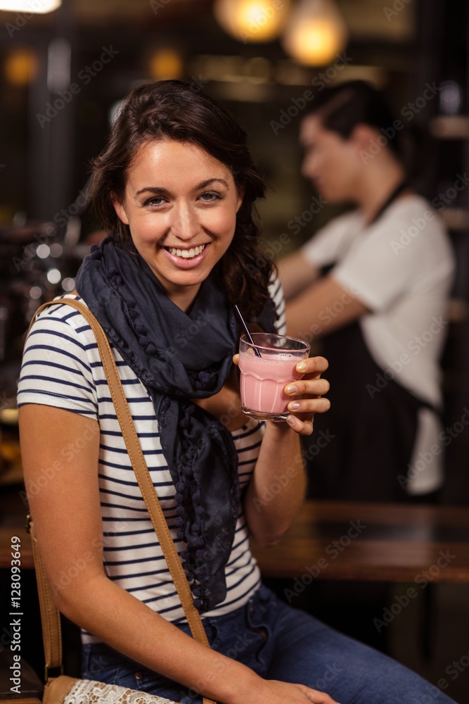 Smiling brunette drinking a beverage Smiling brunette drinking a beverage