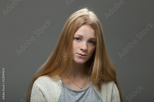 Human face expressions and emotions. Portrait of young adorable redhead woman with pouting lips in cozy shirt looking confused.