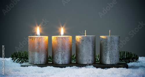 Zweite Advent - Vier silberne Adventskerzen mit zwei angezündeten Kerzen