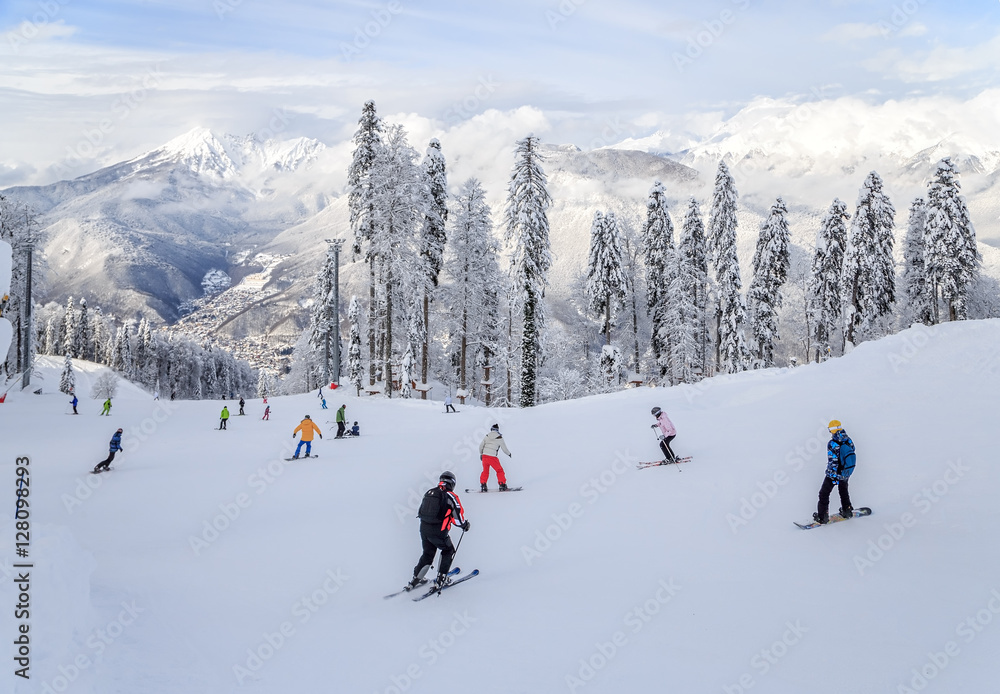 Skiers and snowboarders riding on a ski slope Skiers and snowboarders riding on a ski slope