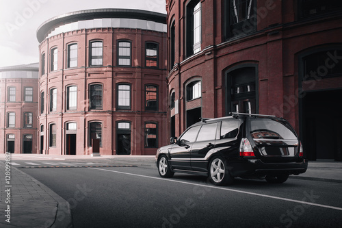 Black car standing near modern loft buildings © Ivan Kurmyshov