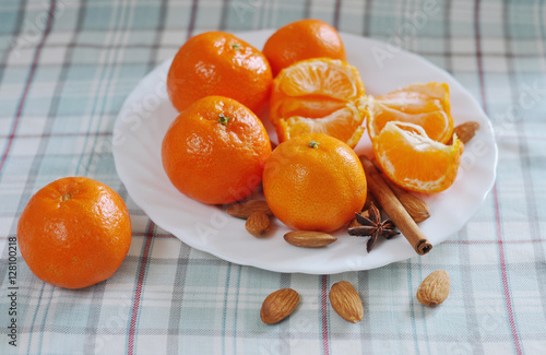 Several mandarins lie on a white dish