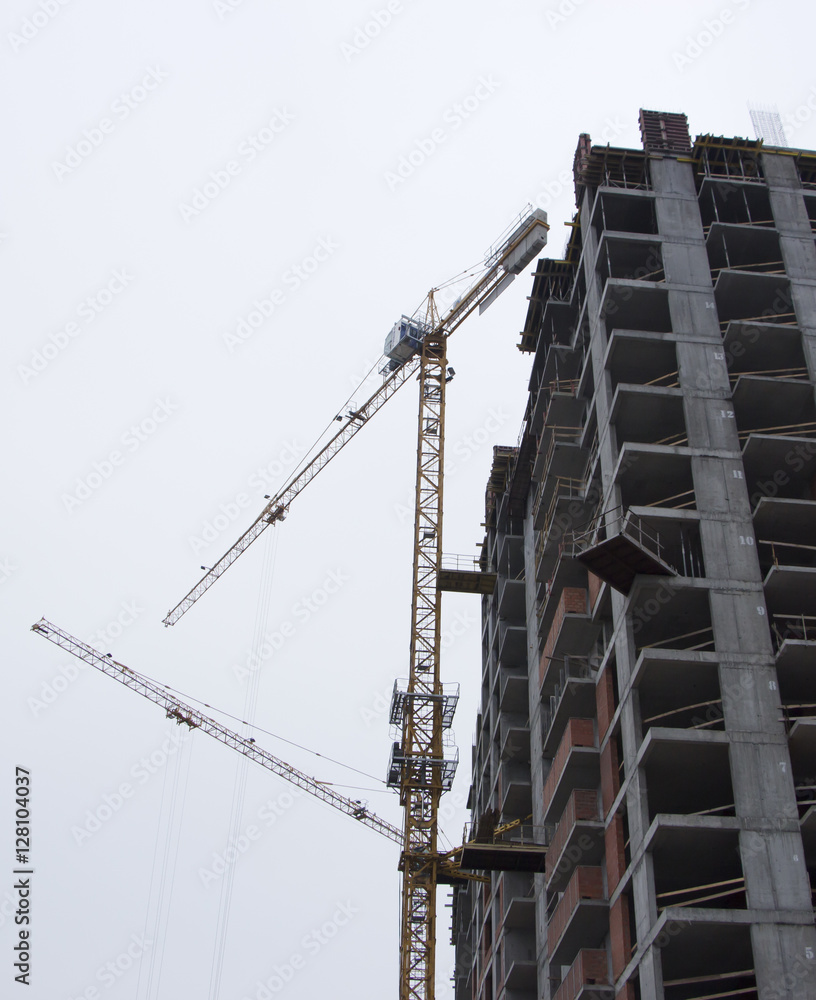 Naklejka premium Residential buildings construction site with three working tower cranes