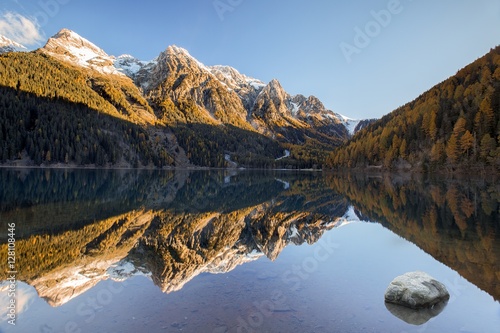 The Anterselva lake framed by the gold of larch trees in a morning of autumn , Bolzano, Rasun Anterselva, South Tyrol, Italy photo