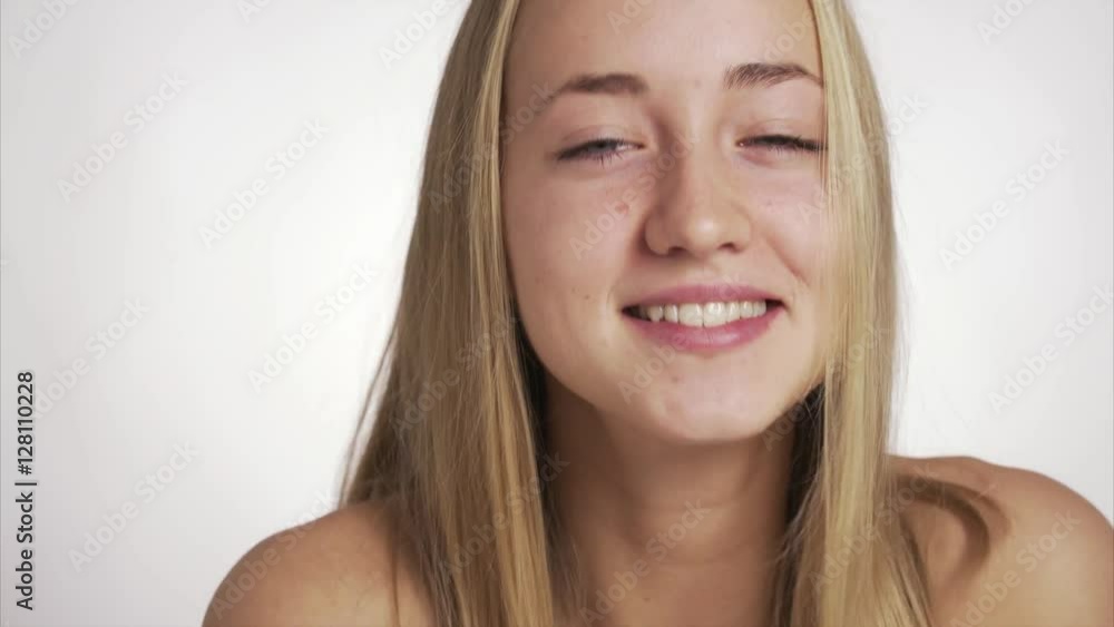 Beauty video of a young blonde pretty woman close up looking at the camera and smiling Beauty video of a young blonde pretty woman close up looking at the camera and smiling