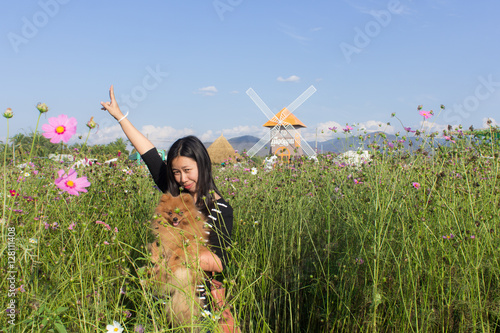 Thai woman and pomeranian with turbine in cosmos field, Muangkae photo