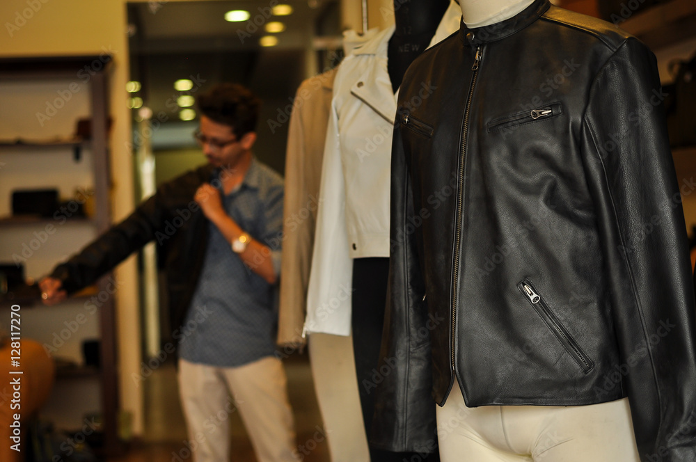 Photograph of beautiful leather jackets with buyer at a leather jacket store. No human figure included in the frame. 