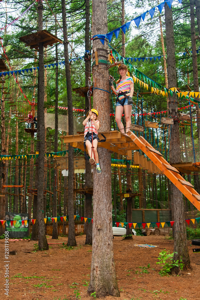 Fototapeta premium Woman and girl climbing in adventure park