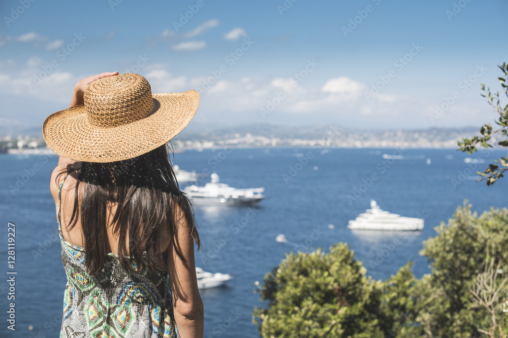 Woman with summer hat watching yachts