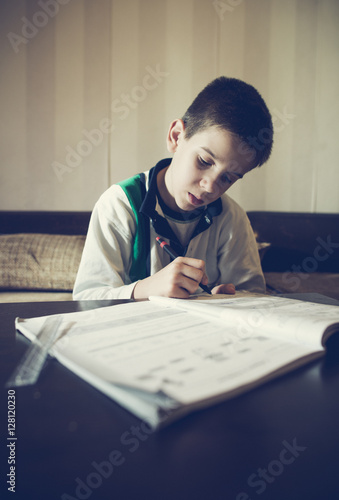 Child do his homework. Hand hold pen. Boy learning
