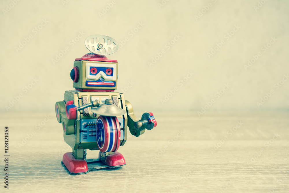Fototapeta premium Old robot toy on wood table, vintage color style, vintage tone background.