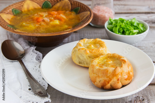 Russian traditional pies kurniki with cabbage soup.