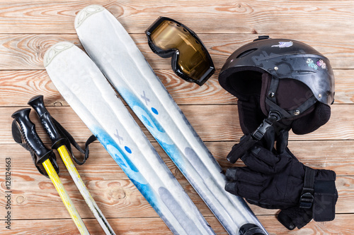 Overhead view of ski accessories placed on rustic wooden table.