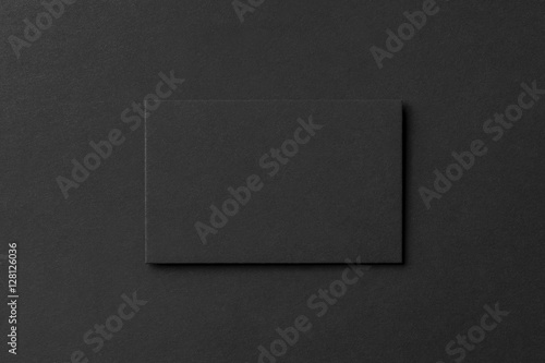Mockup of blank business card at black textured background.