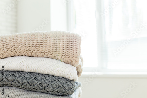 Stack of white cozy knitted sweaters