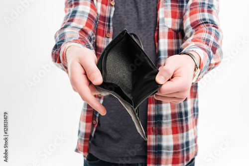 Closeup image of a man in shirt holding emty wallet