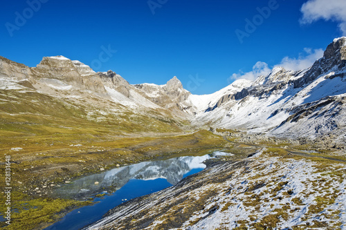 Blue mountain lake within snow capped peaks  Swiss Alps