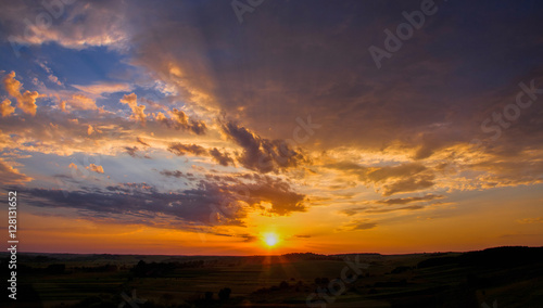 sunset over meadow with green grass