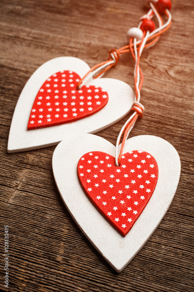 Fototapeta premium White and red sewed christmas hearts on wooden background