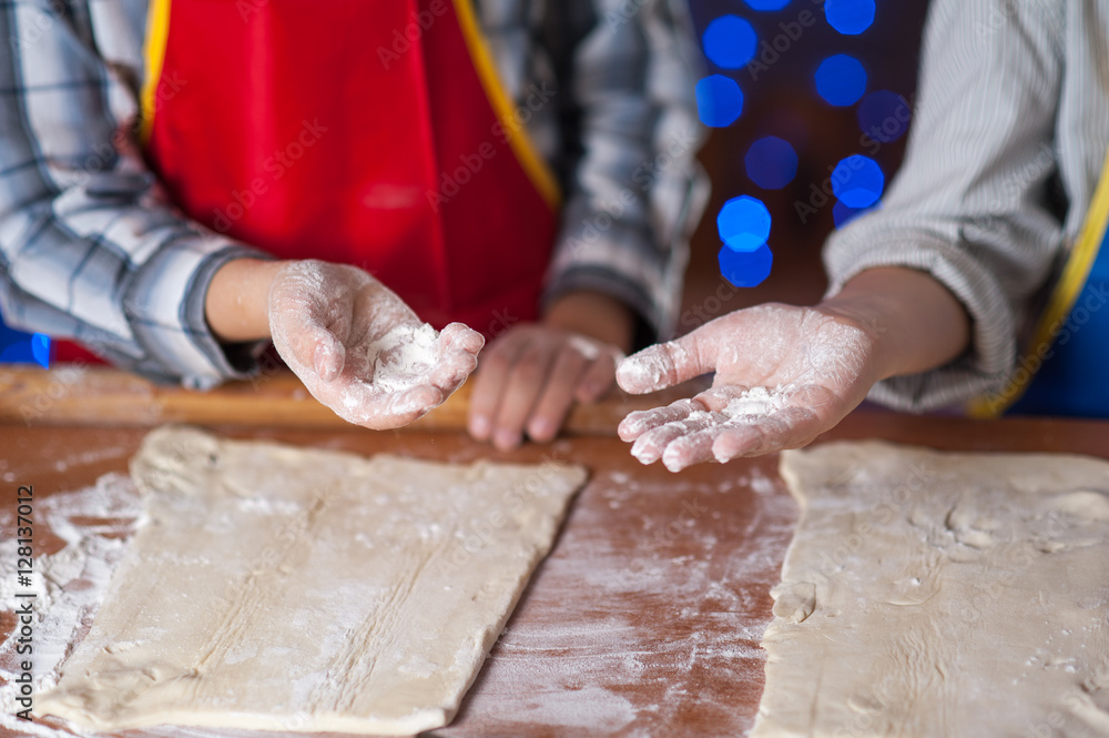 hands of a child who is preparing cookies in the kitchen