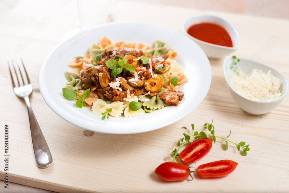 Farfalle with meat, mushrooms, olives and basil on a classic wood. Farfalle with meat, mushrooms, olives and basil on a classic wood.