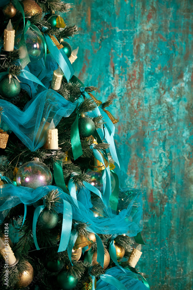 Green New Year tree decorated with toys and balls. Christmas background with grunge plaster wall Green New Year tree decorated with toys and balls. Christmas background with grunge plaster wall
