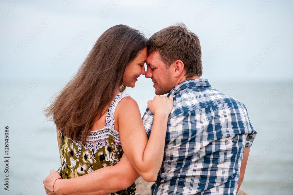 Young couple on the rocks in the sea Young couple on the rocks in the sea