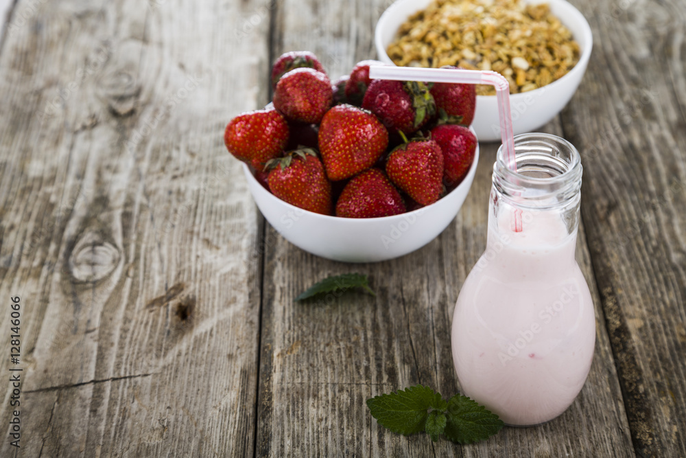 Smoothies and ripe strawberry on a wooden table. Milk drink with Smoothies and ripe strawberry on a wooden table. Milk drink with