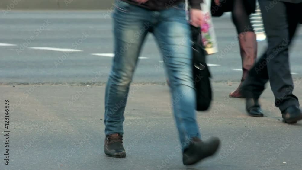 Legs of people who cross the street at a pedestrian crossing. Legs of people who cross the street at a pedestrian crossing.