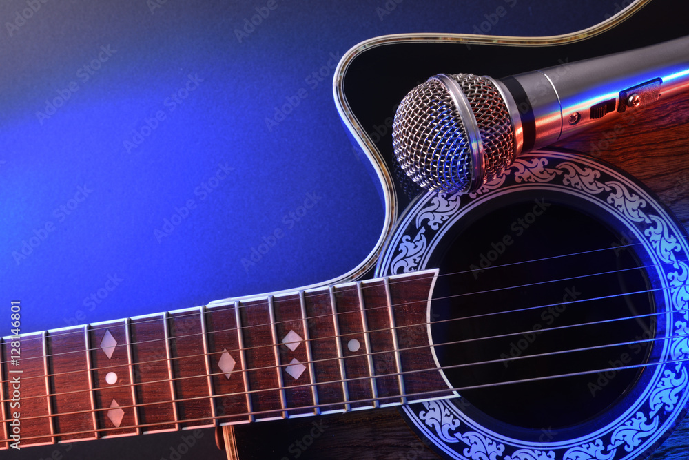Obraz premium Acoustic guitar and microphone isolated with red and blue lights