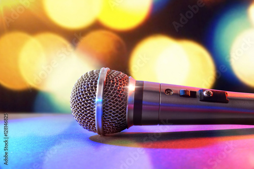 Microphone on black table and colored lights background