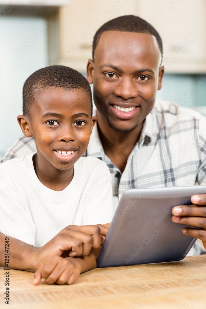 Naklejka premium Father and son using tablet together