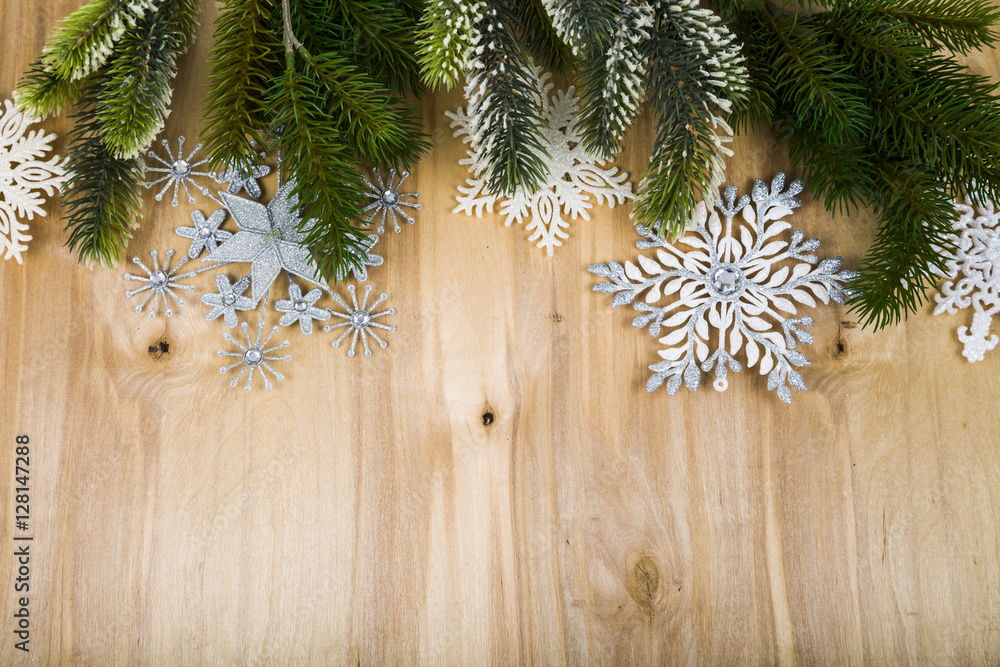 Silver snowflakes and fir branches on a wooden table. Christmas Silver snowflakes and fir branches on a wooden table. Christmas