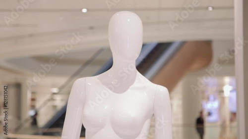 Mannequin or dressmakers dummy on with shopping mall on background. Copy space text.