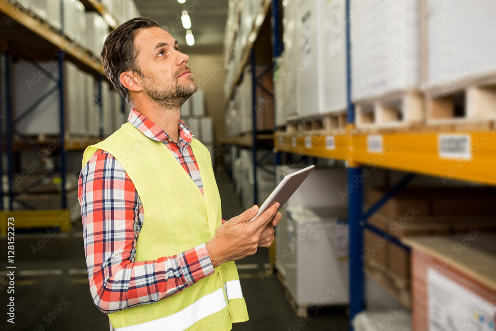 Man in a warehouse checking inventory levels of goods. First in first ...