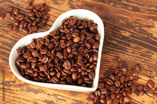 Hei  e Liebe zum Kaffee  Kaffeebohnen in wei  em Porzellanherz 