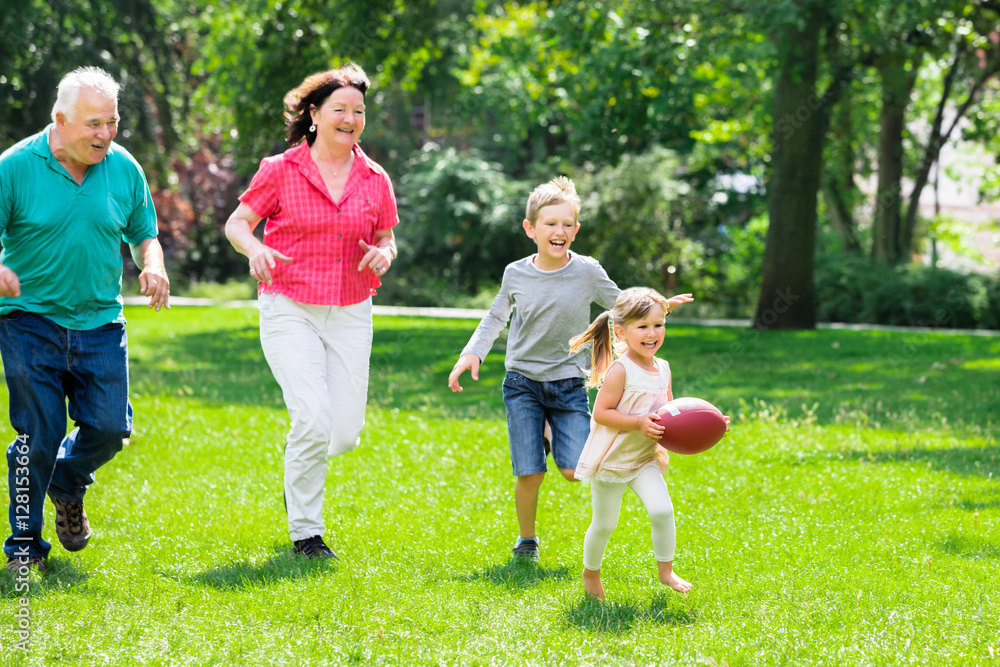 Fototapeta premium Grandparent And Grandchildren Playing With Rugby Ball