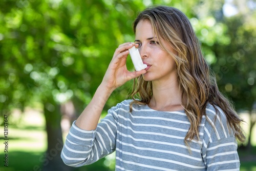 Woman using asthma inhaler photo