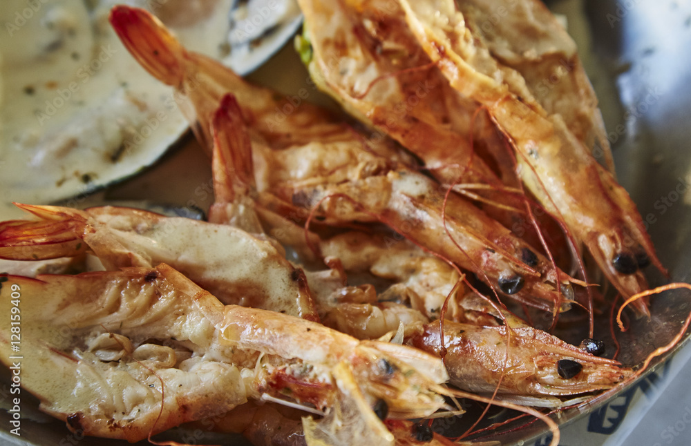 tasty shrimps, mussels, fish with lemon on metal plate tasty shrimps, mussels, fish with lemon on metal plate