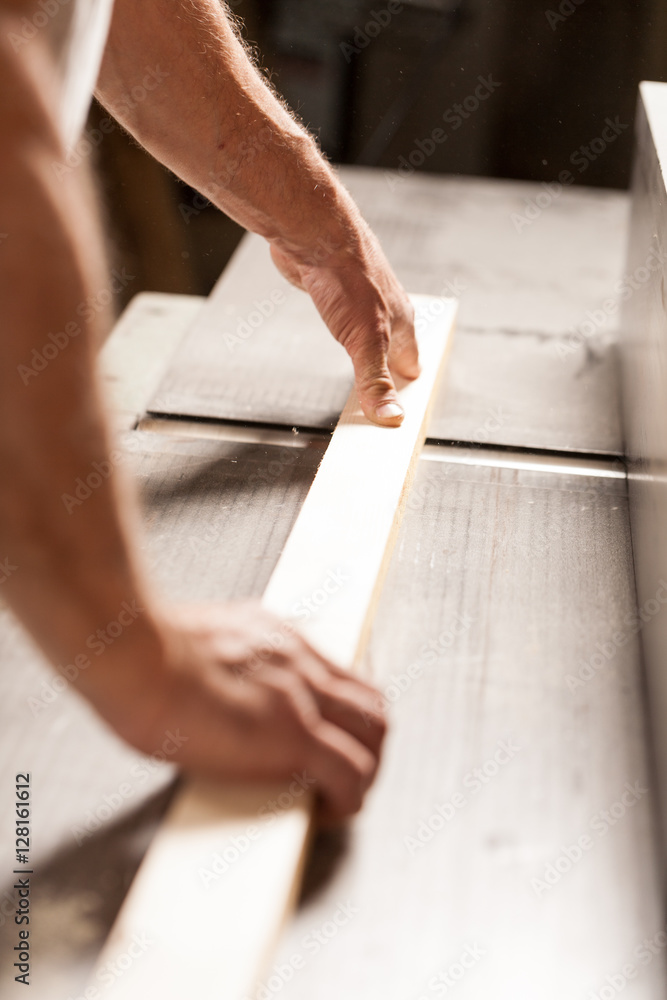 hands shaving a plank on a surface planner