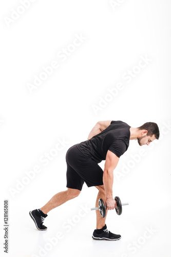 Full length bodybuilder doing exercises with dumbbell