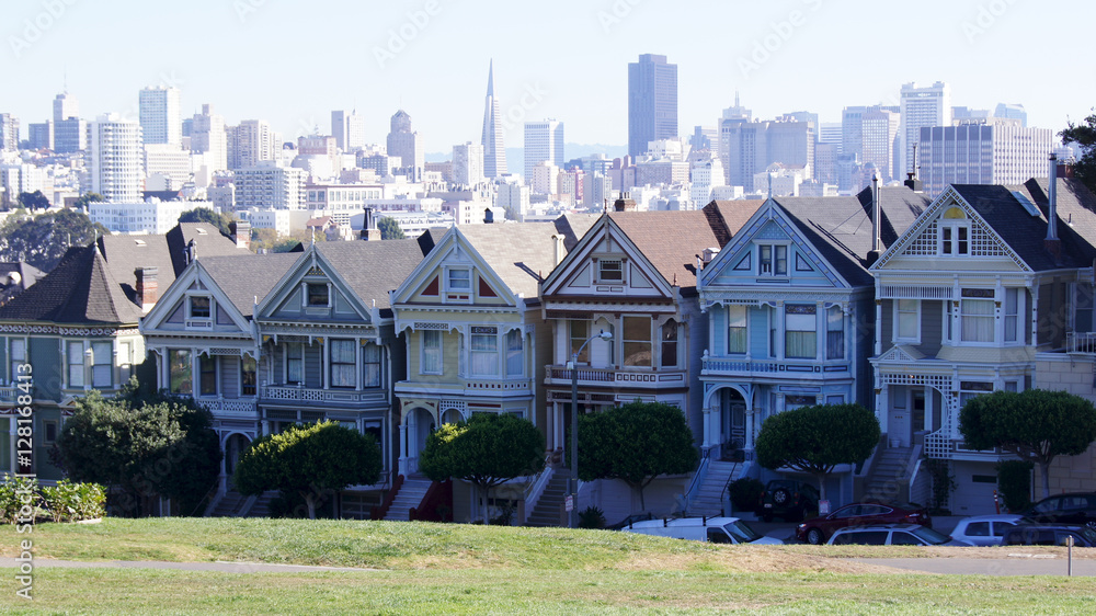 SAN FRANCISCO, USA - OCTOBER 5th, 2014: Painted Ladies with SF skyline in the background as seen from Alamo Square. SAN FRANCISCO, USA - OCTOBER 5th, 2014: Painted Ladies with SF skyline in the background as seen from Alamo Square.