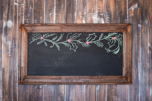 Front view of a blank blackboard over weathered wooden surface
